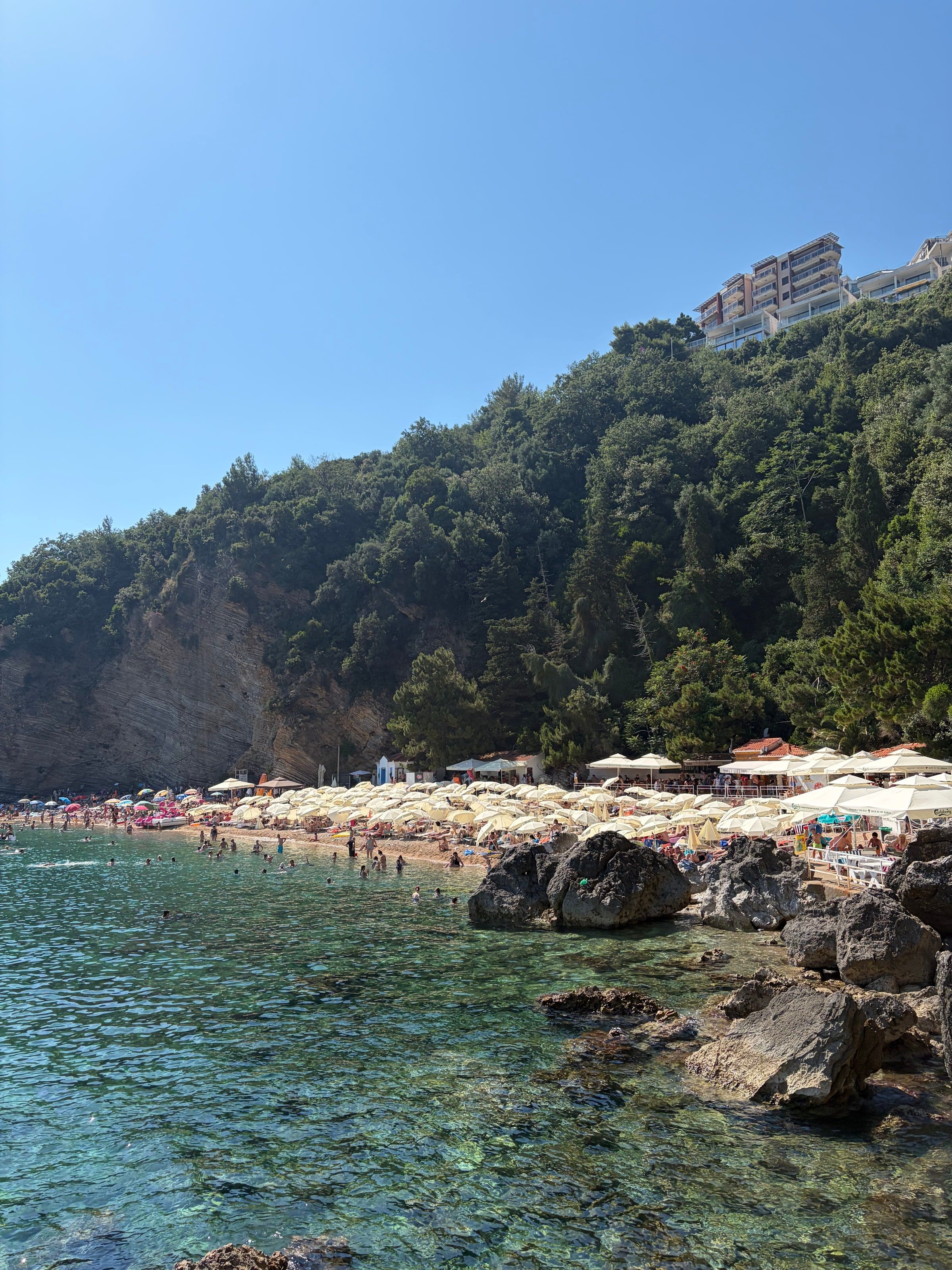 Playa con sombrillas y rocas camino a Mogren
