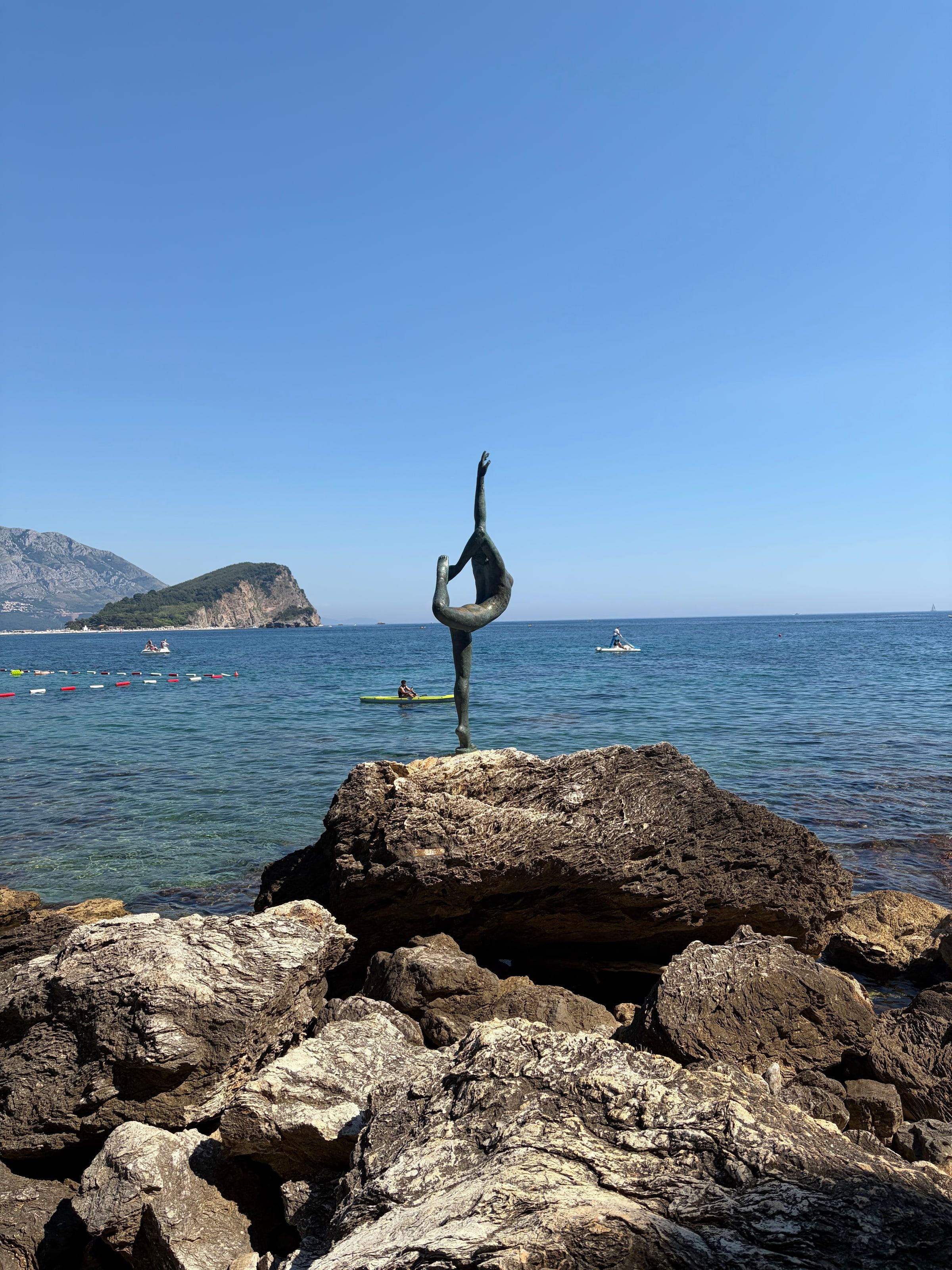 La estatua de la bailarina sobre una roca frente al mar