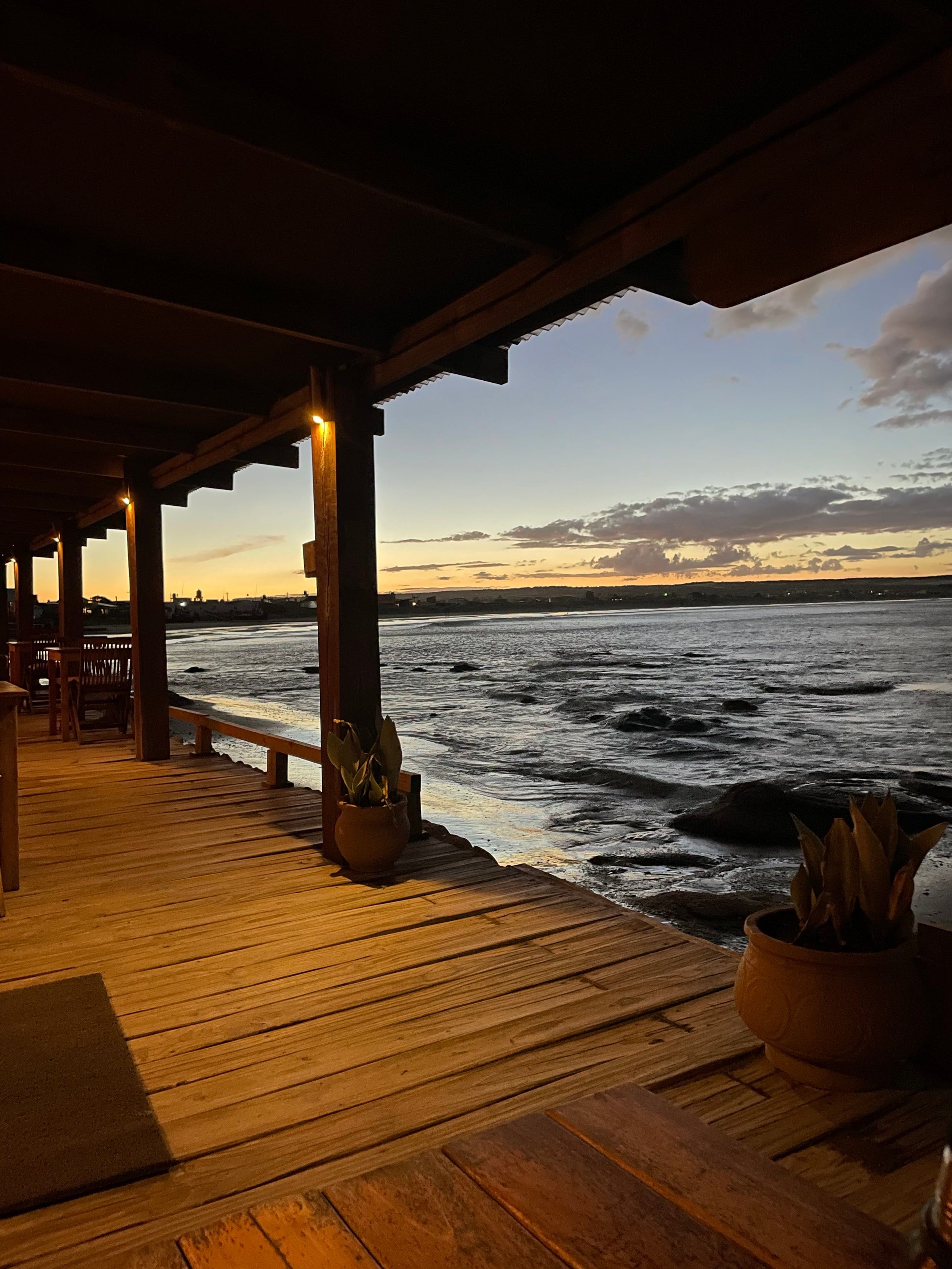 Atardecer sobre el mar en Cabo Polonio, visto desde un deck de madera