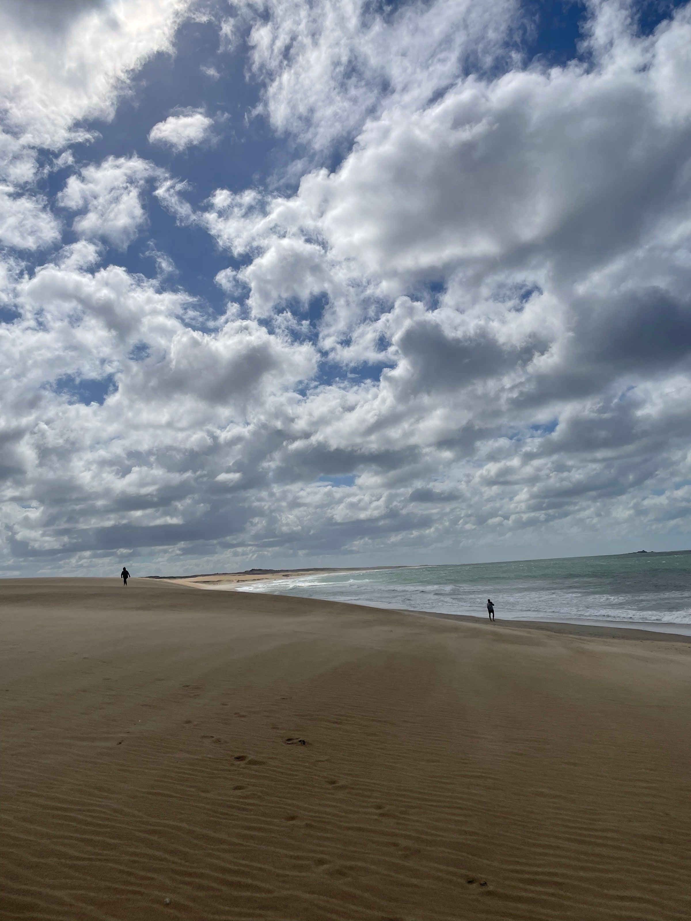 La playa con la arena y el cielo nublado