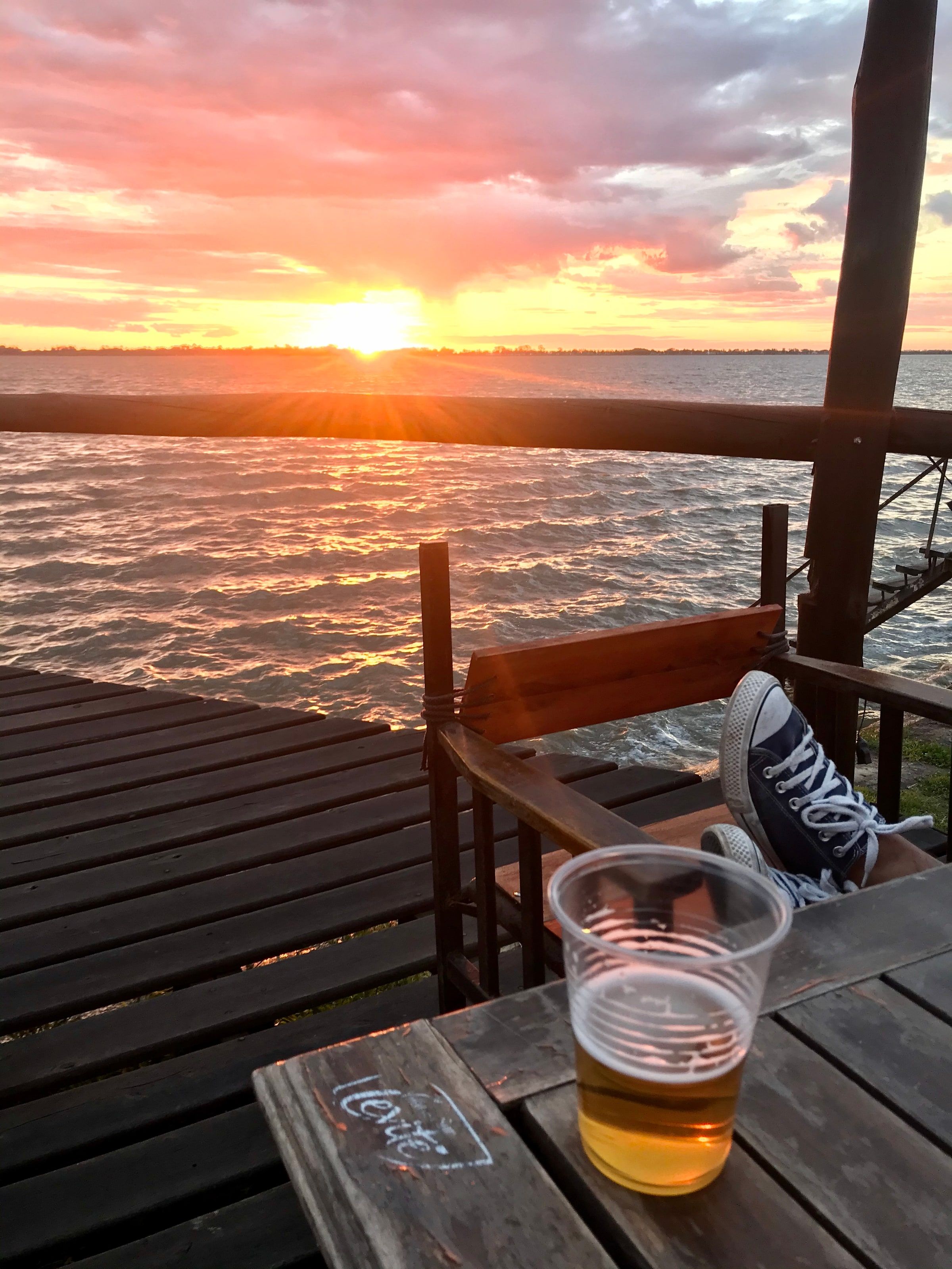 Un deck sobre la laguna con una cerveza