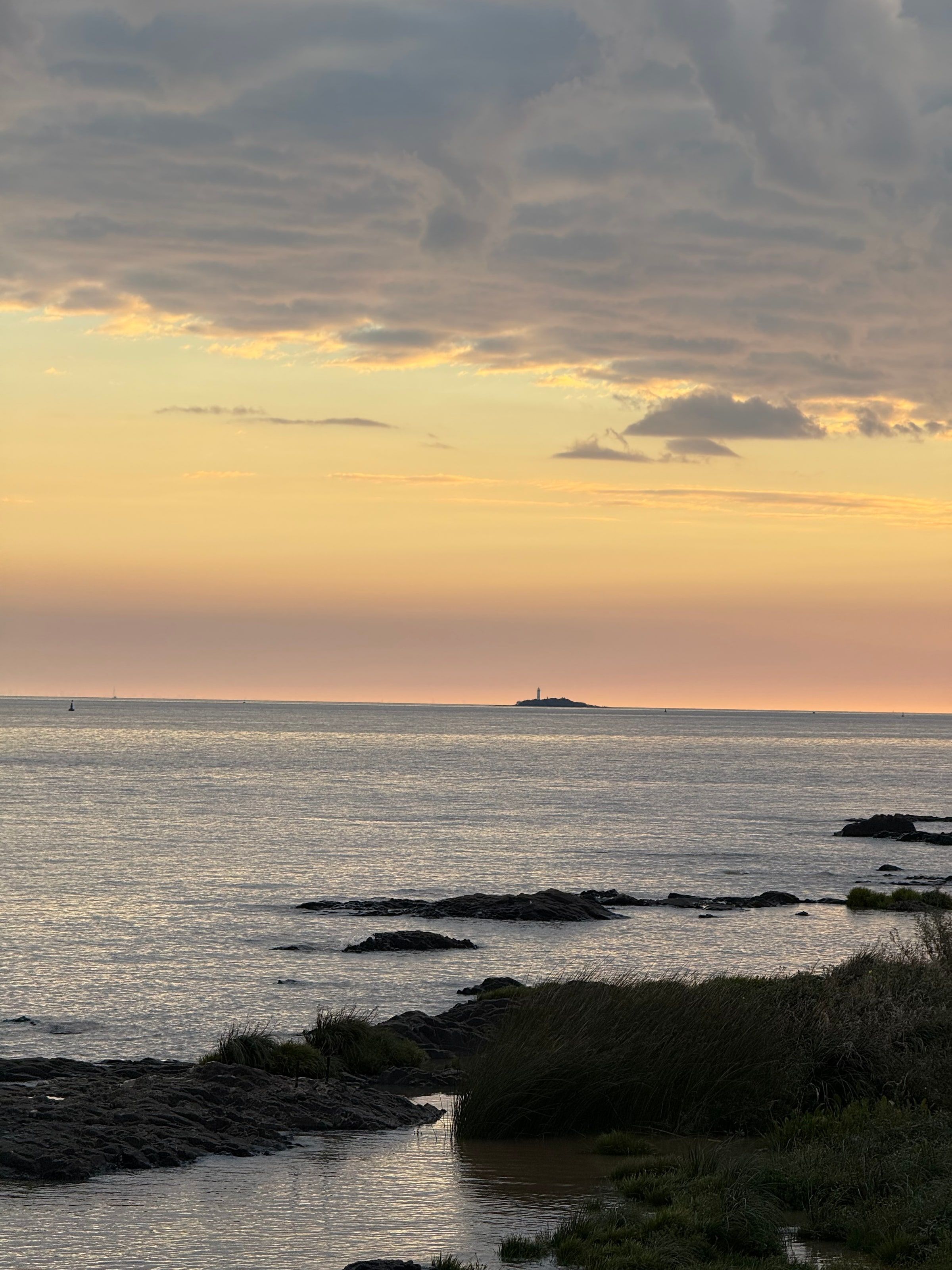 Atardecer sobre el Río de la Plata, con el faro a lo lejos