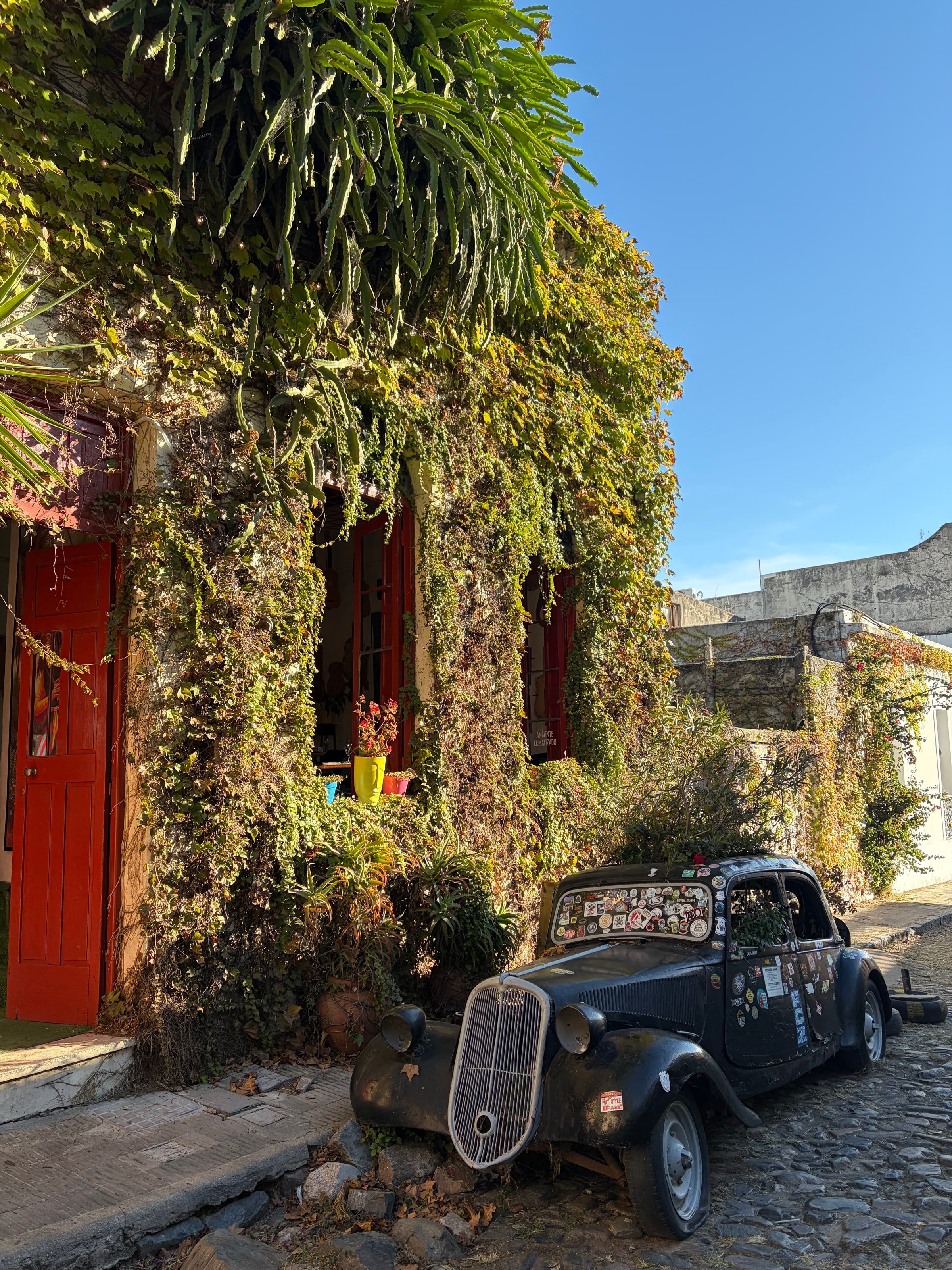Un auto antiguo frente a una puerta roja
