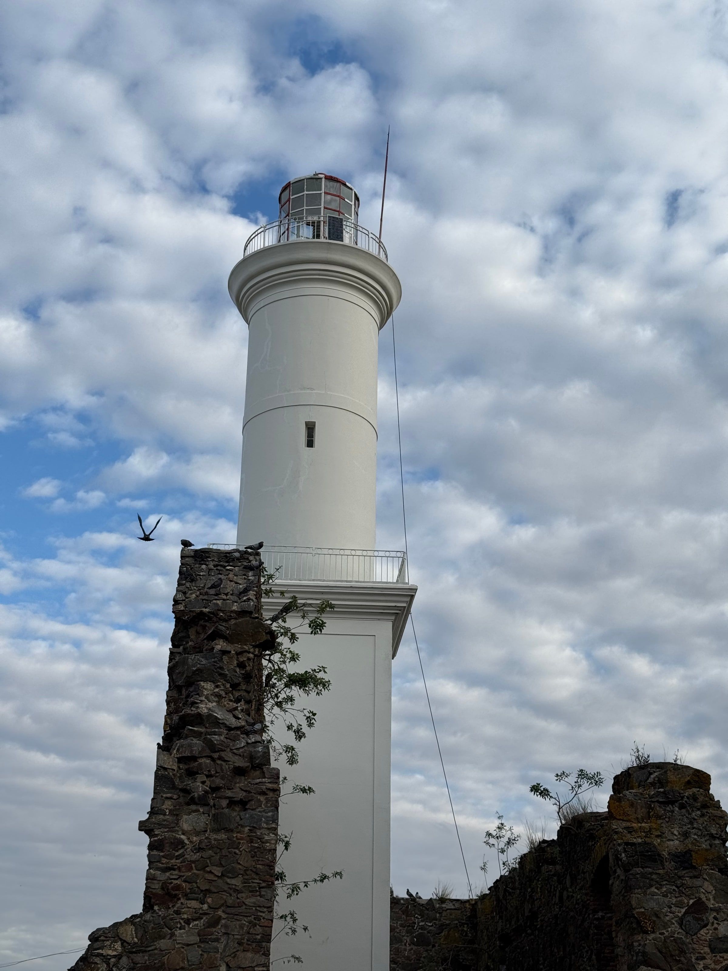 El faro blanco sobre el muro de piedra