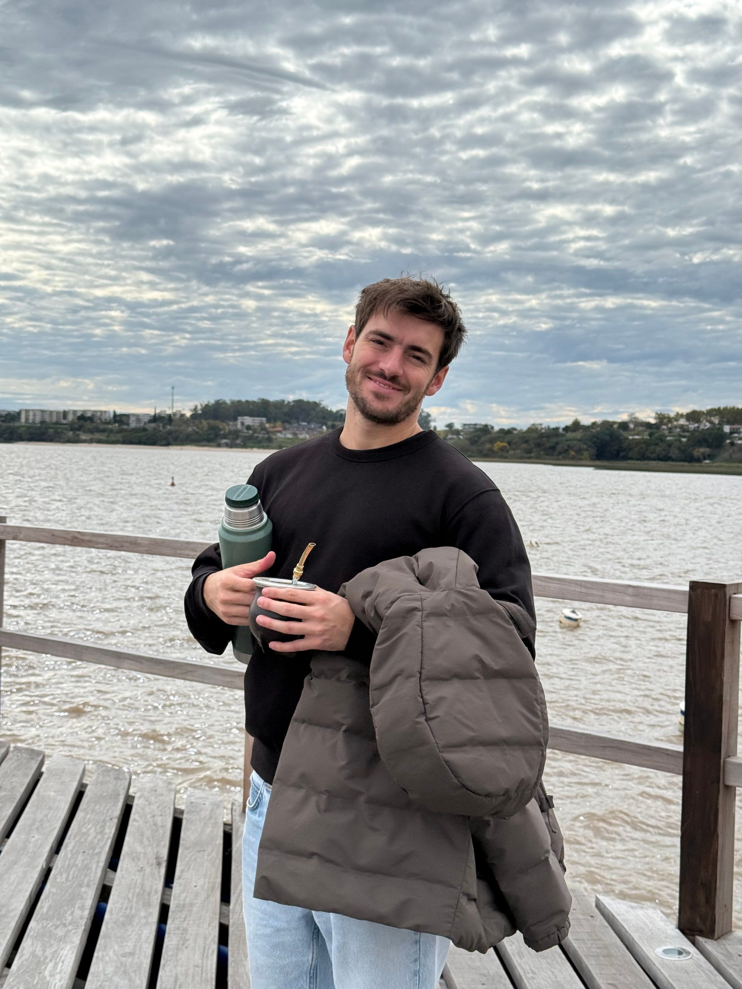 Tomi en el muelle de madera, con el río detrás