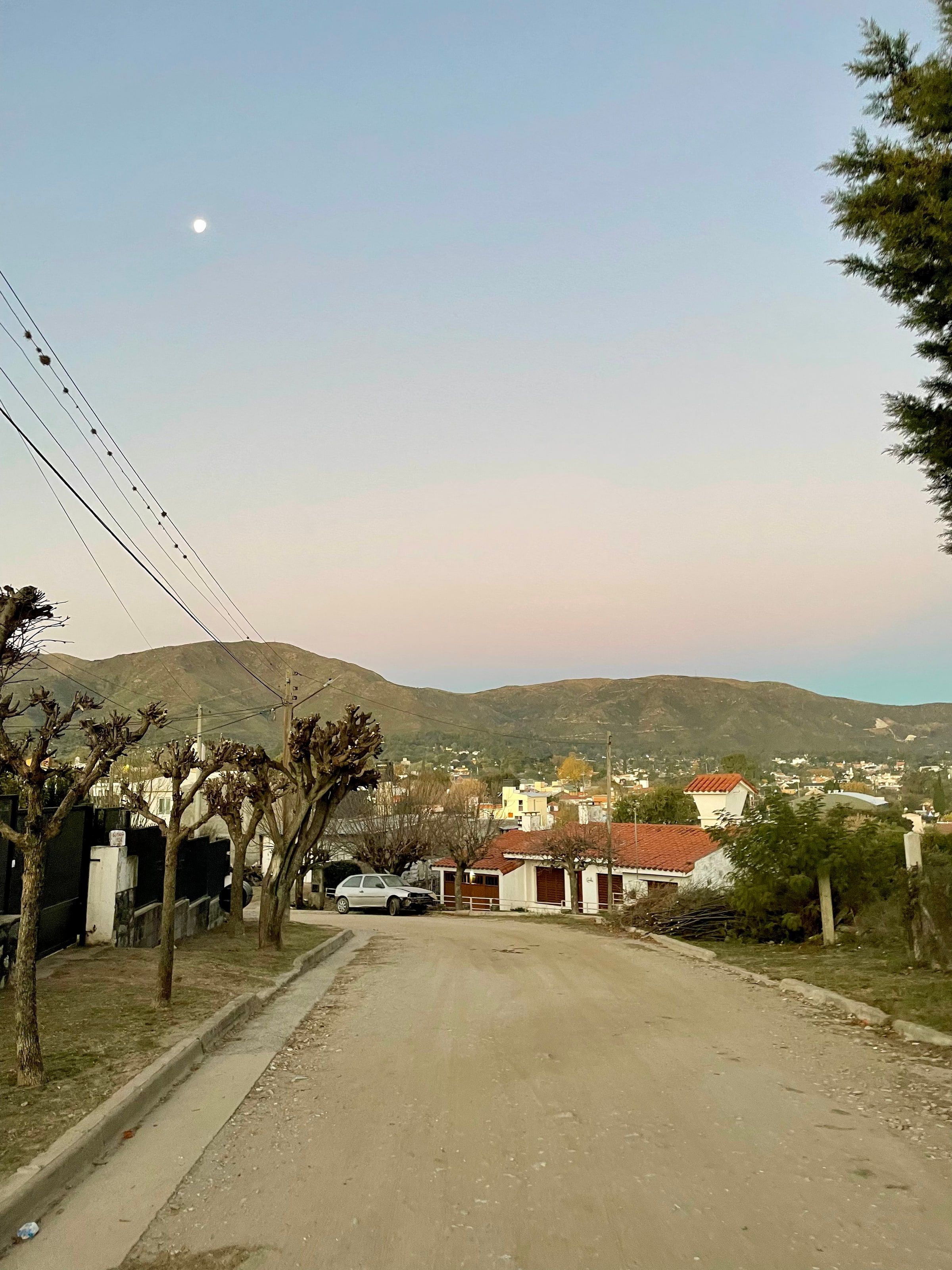 Una calle de La Falda con las sierras atrás