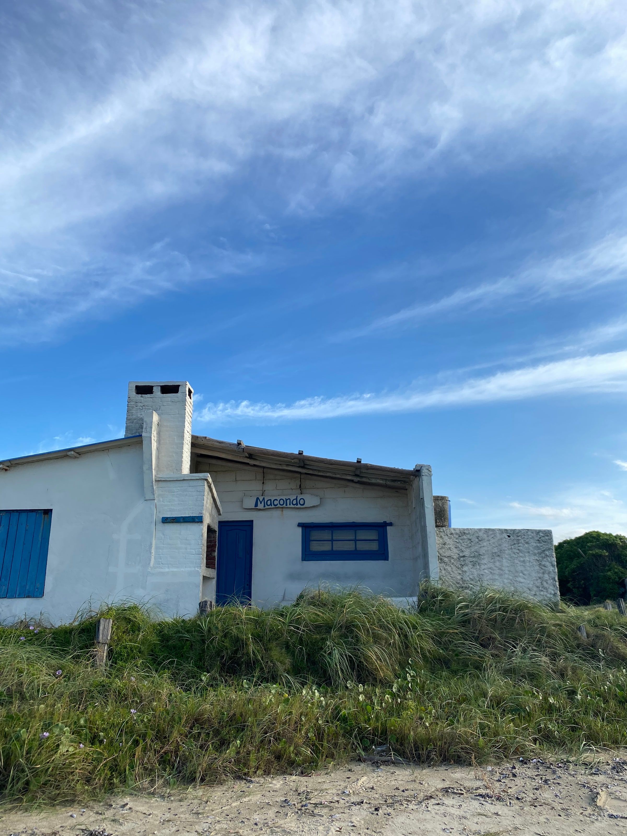 Casa blanca con puerta azul y chimenea en el pueblo