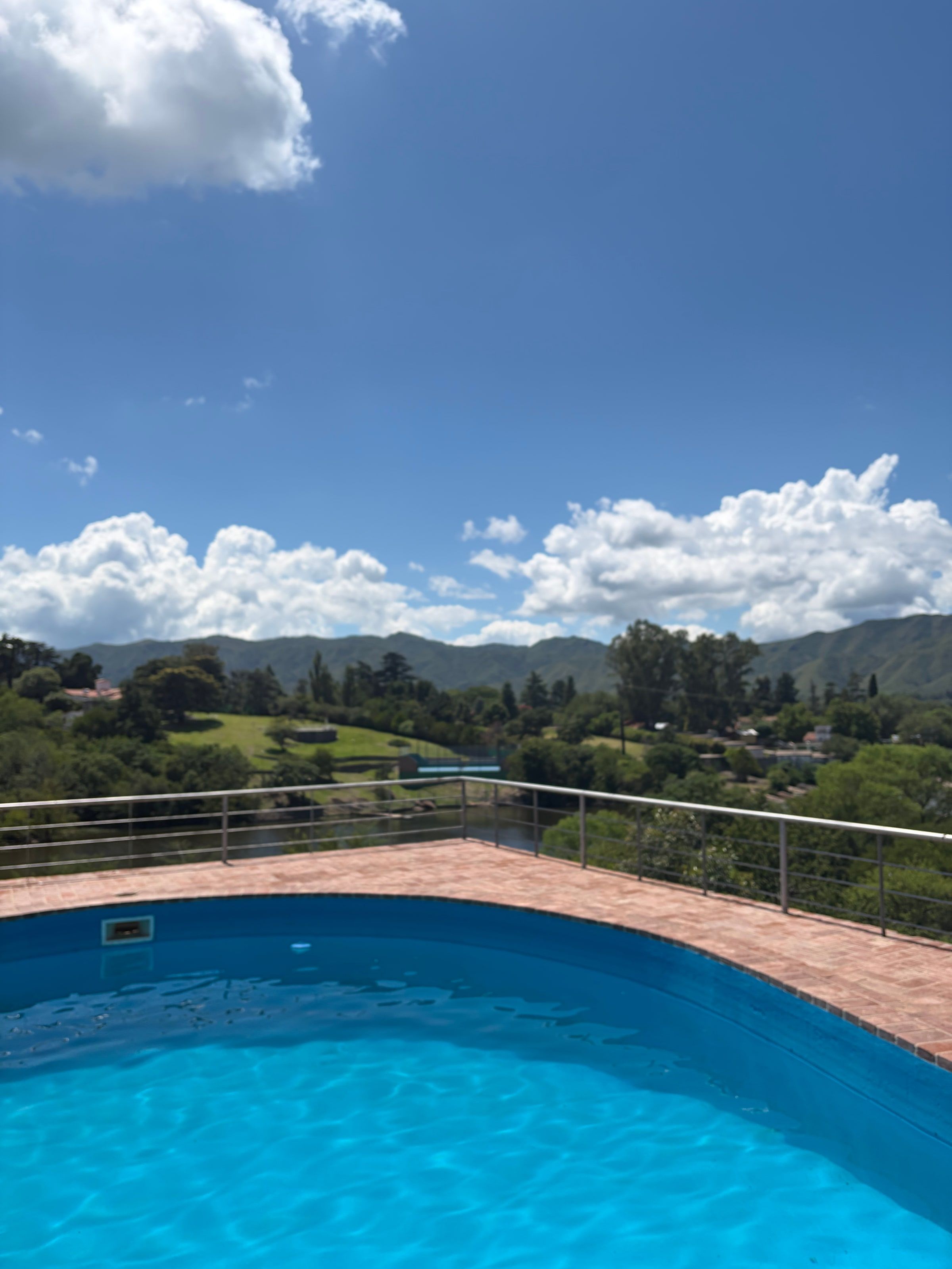 Una pileta con las sierras de Punilla atrás