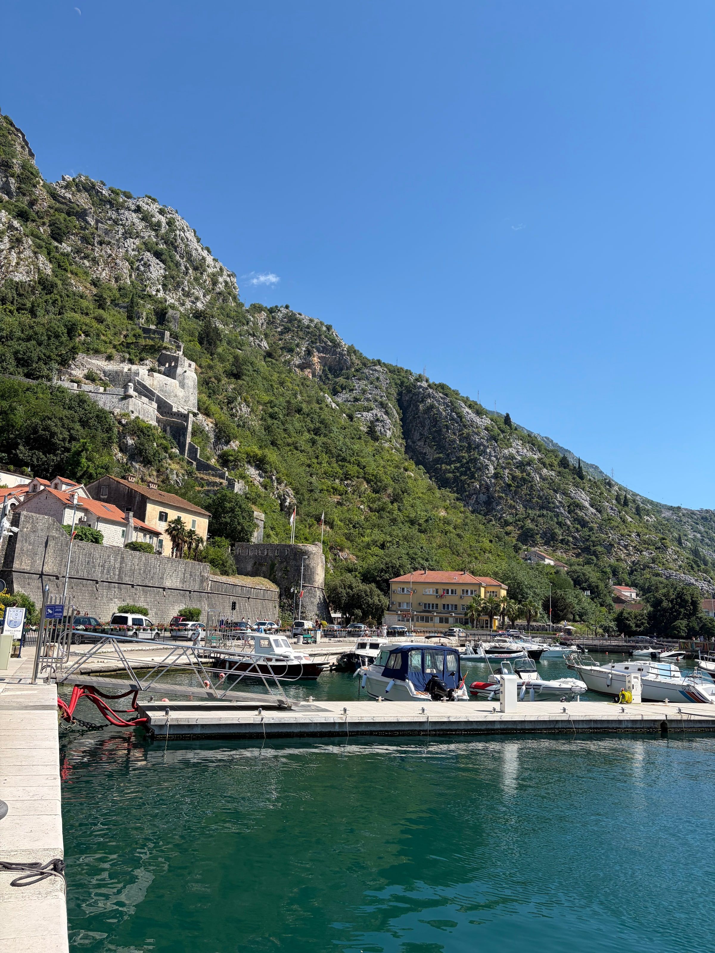 El puerto de Kotor con botes y la montaña