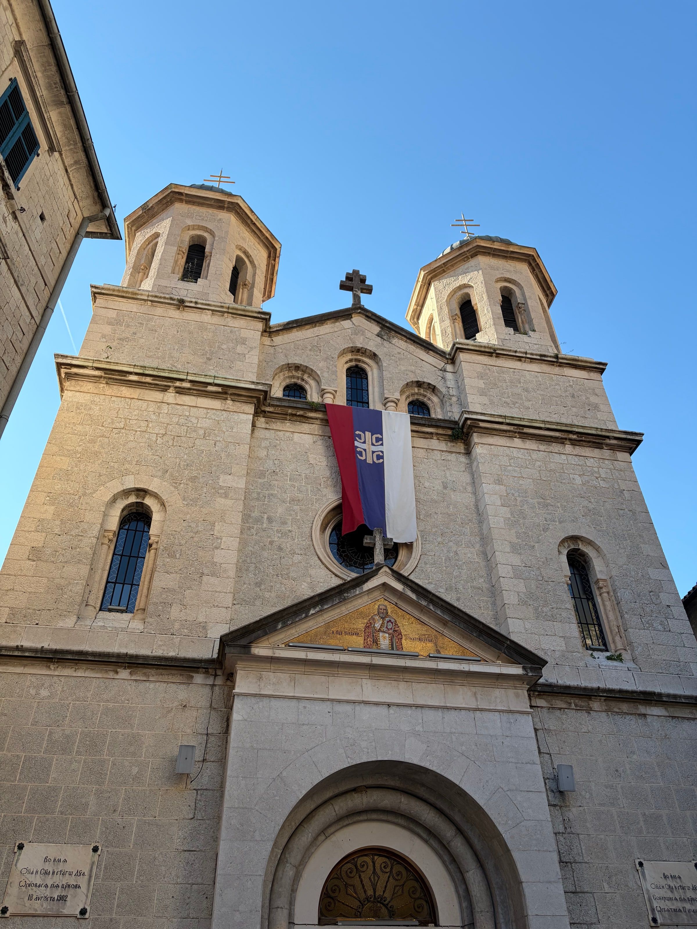 Una iglesia con campanario y bandera en la plaza de San Lucas