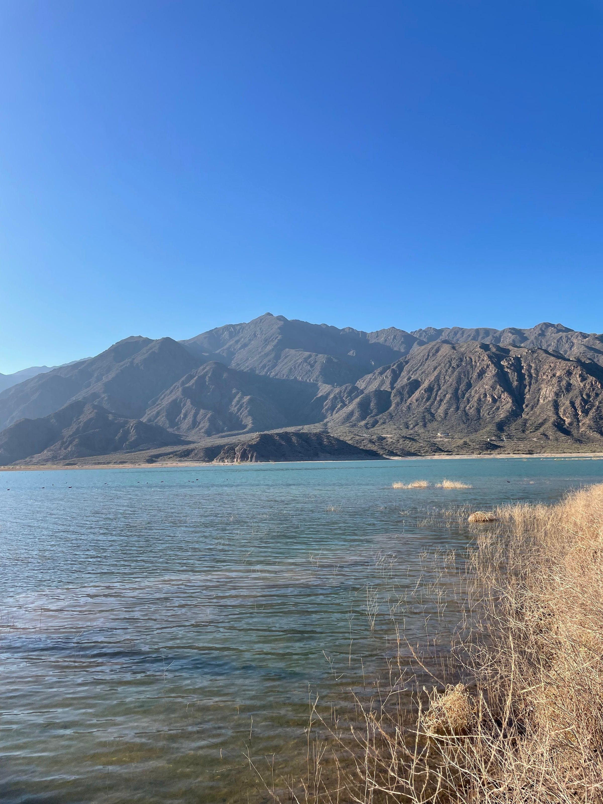La orilla del embalse con los cerros detrás