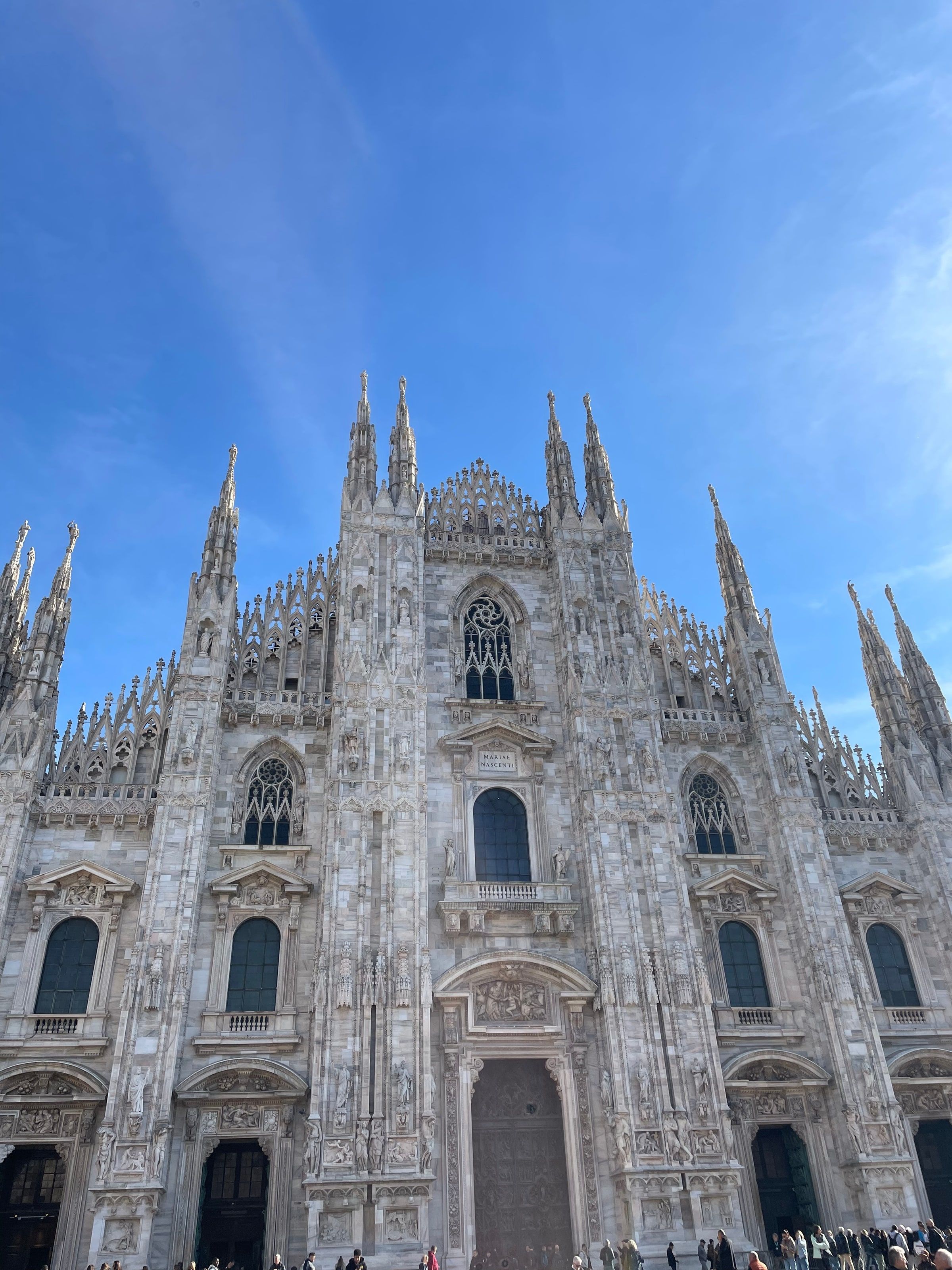 La fachada del Duomo de Milán con cielo azul