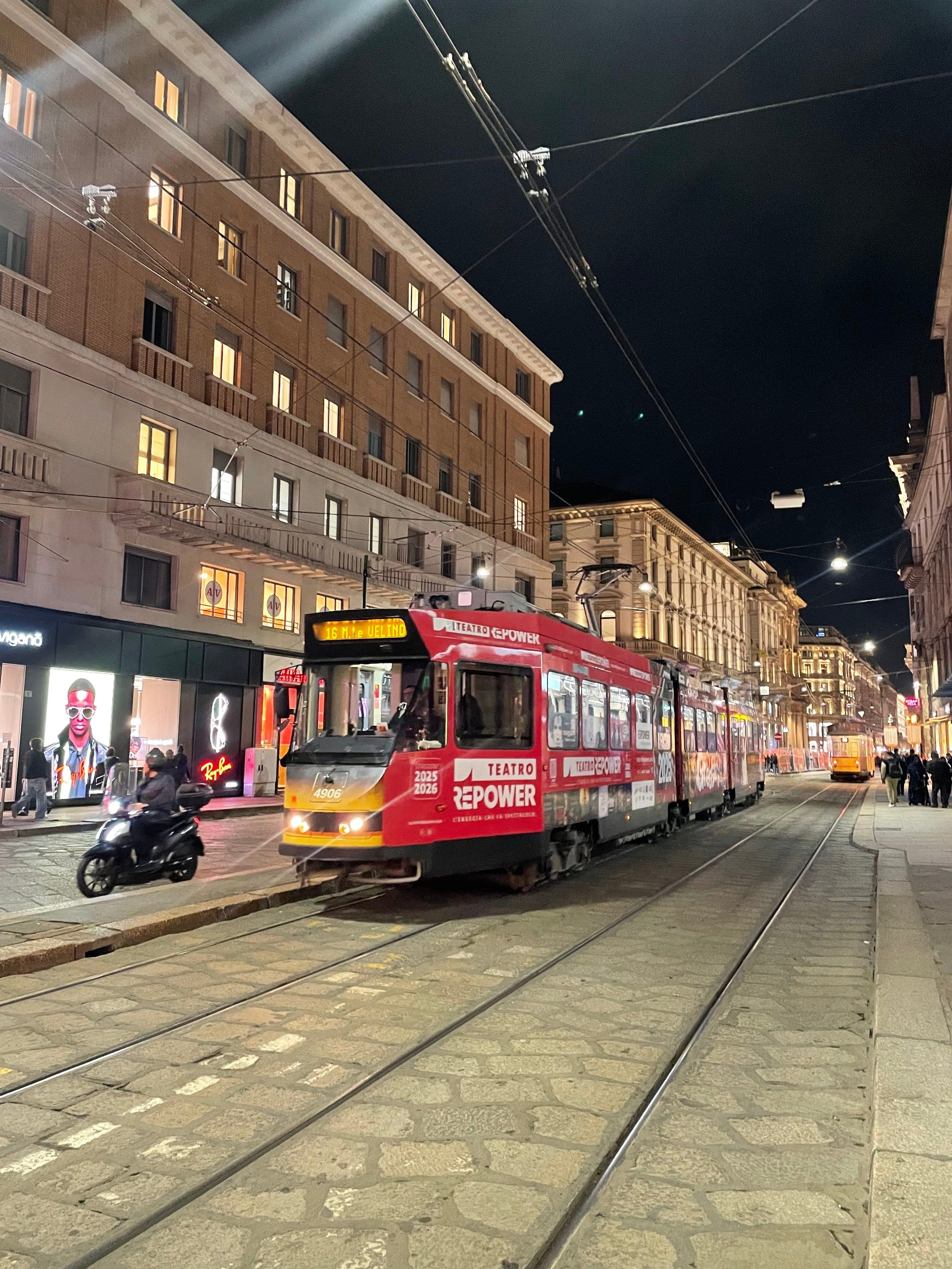 Un tranvía rojo de noche en Via Orefici, Milán