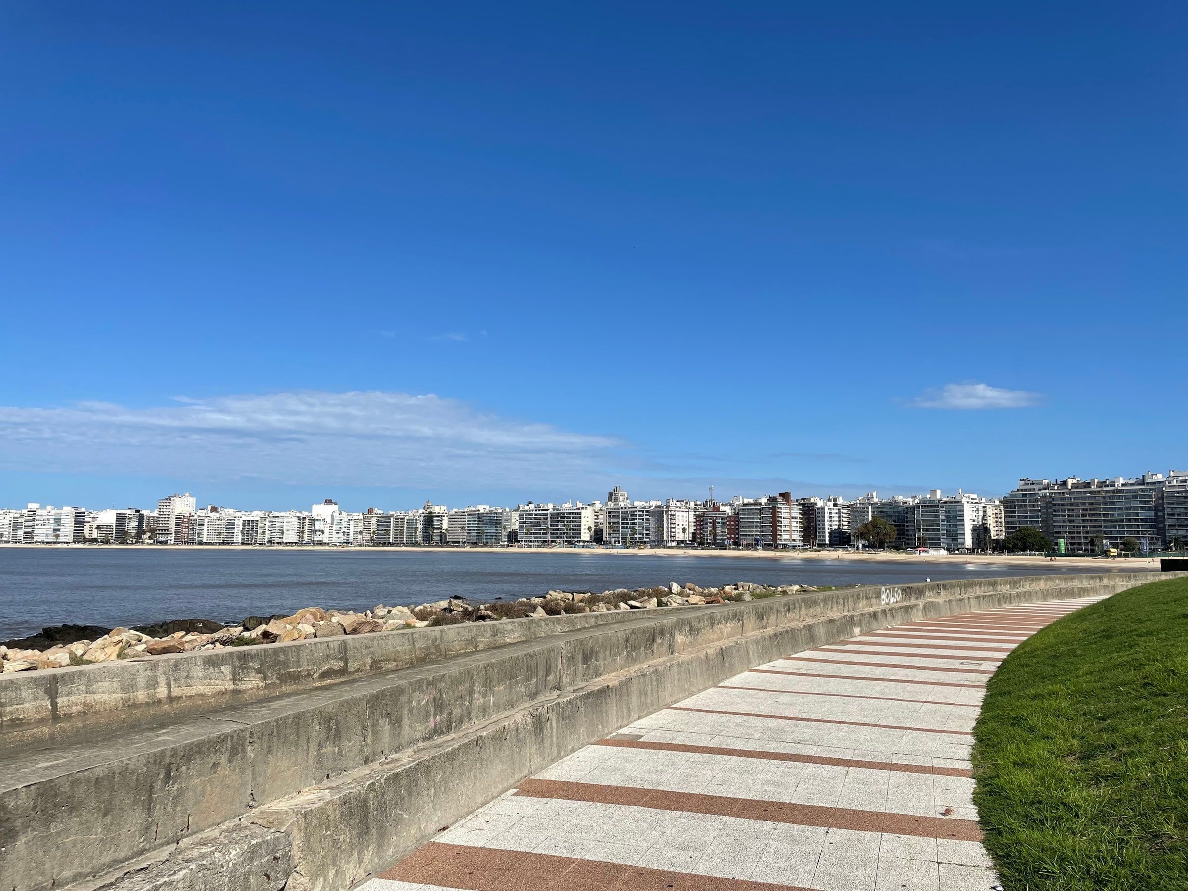 La Rambla de Montevideo de día, con la vereda junto al agua y edificios al fondo