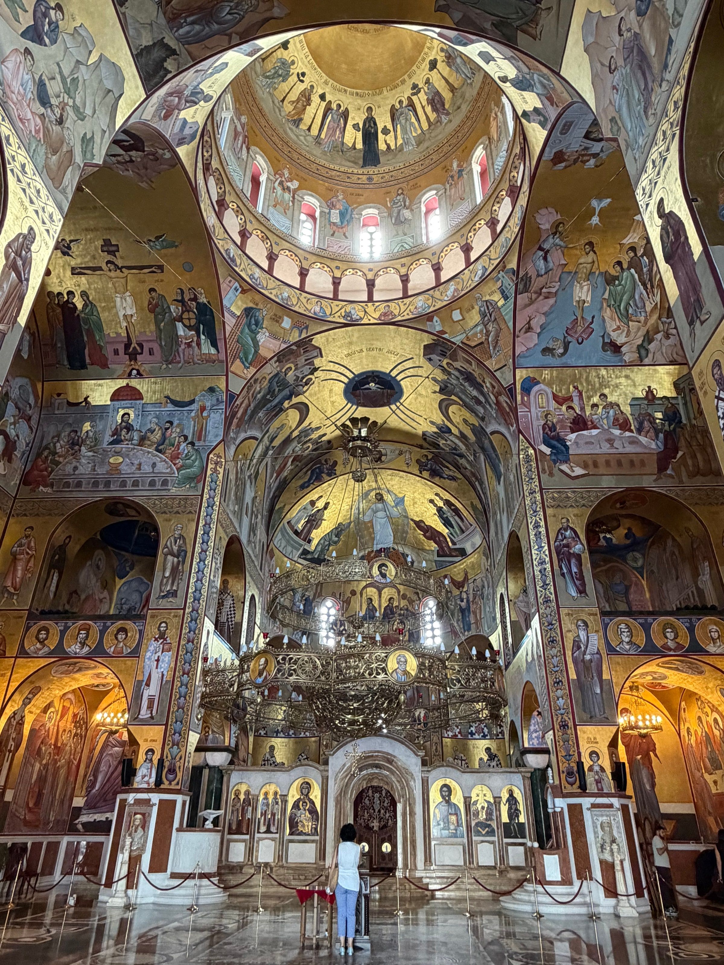 El interior de la catedral con frescos dorados y una araña