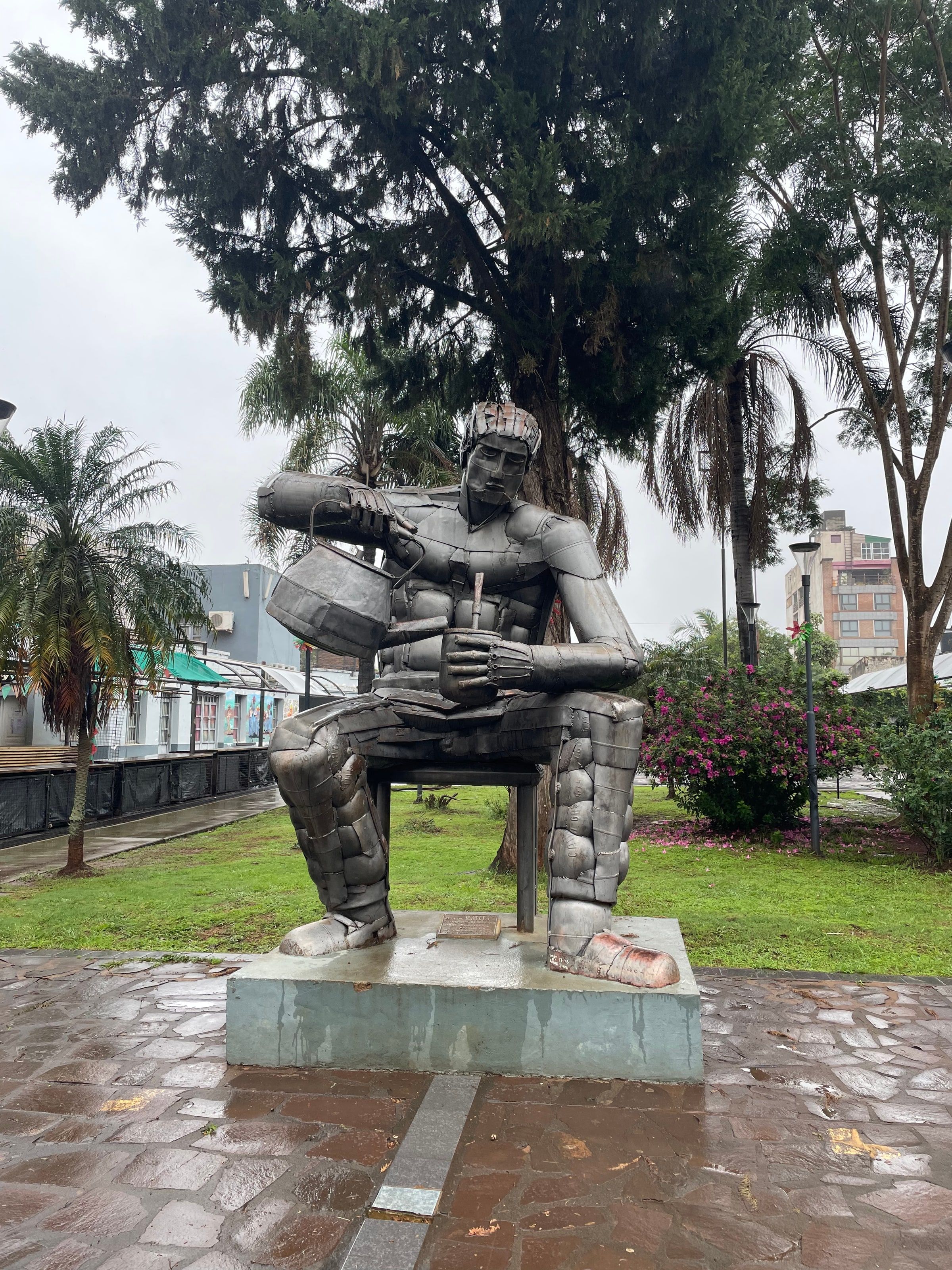 Una estatua de bronce de un hombre sentado, en la costanera