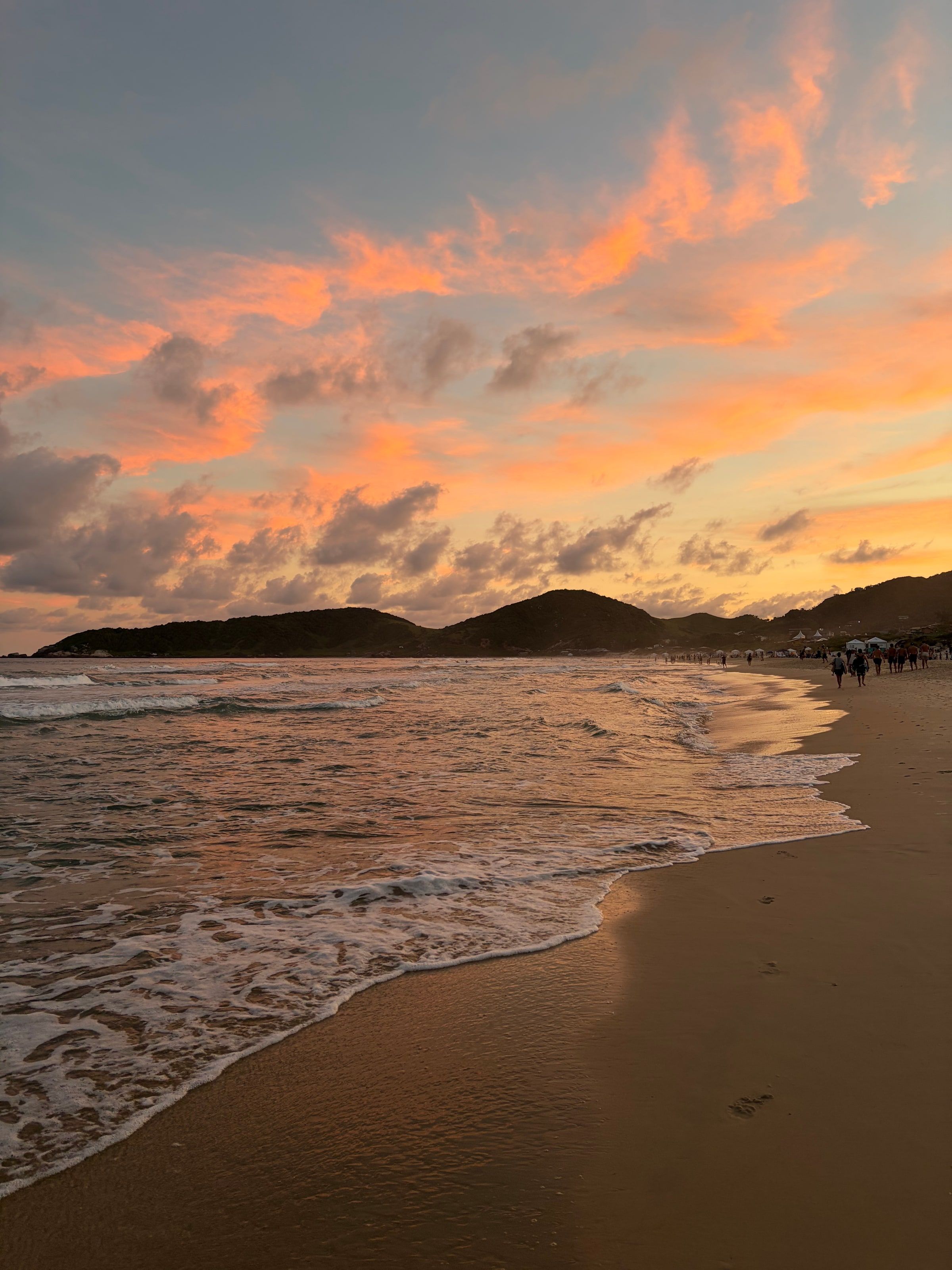 Atardecer naranja sobre el cerro en Praia do Rosa, desde la orilla