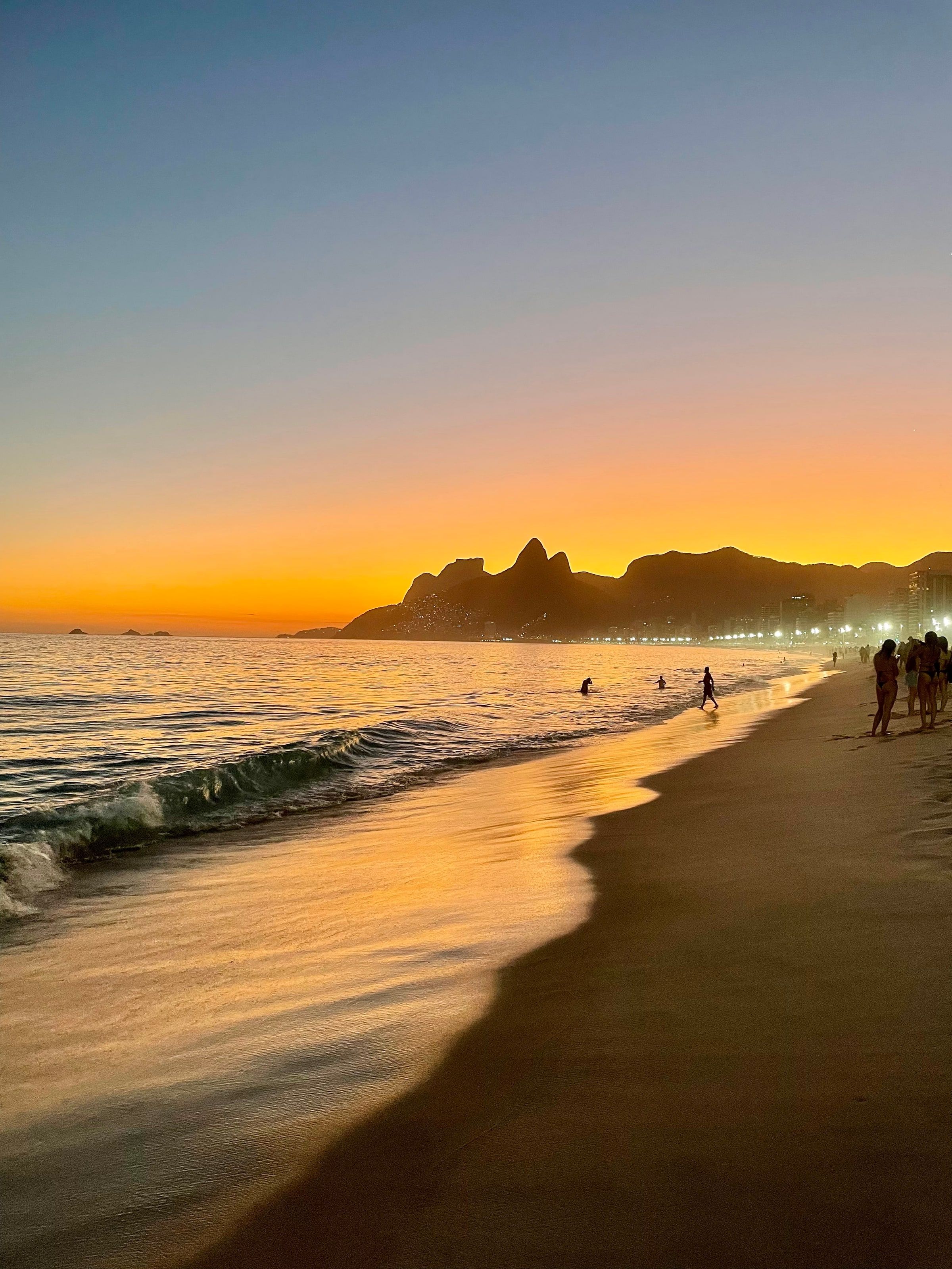 Atardecer naranja en la playa de Ipanema, con el morro Dois Irmãos al fondo