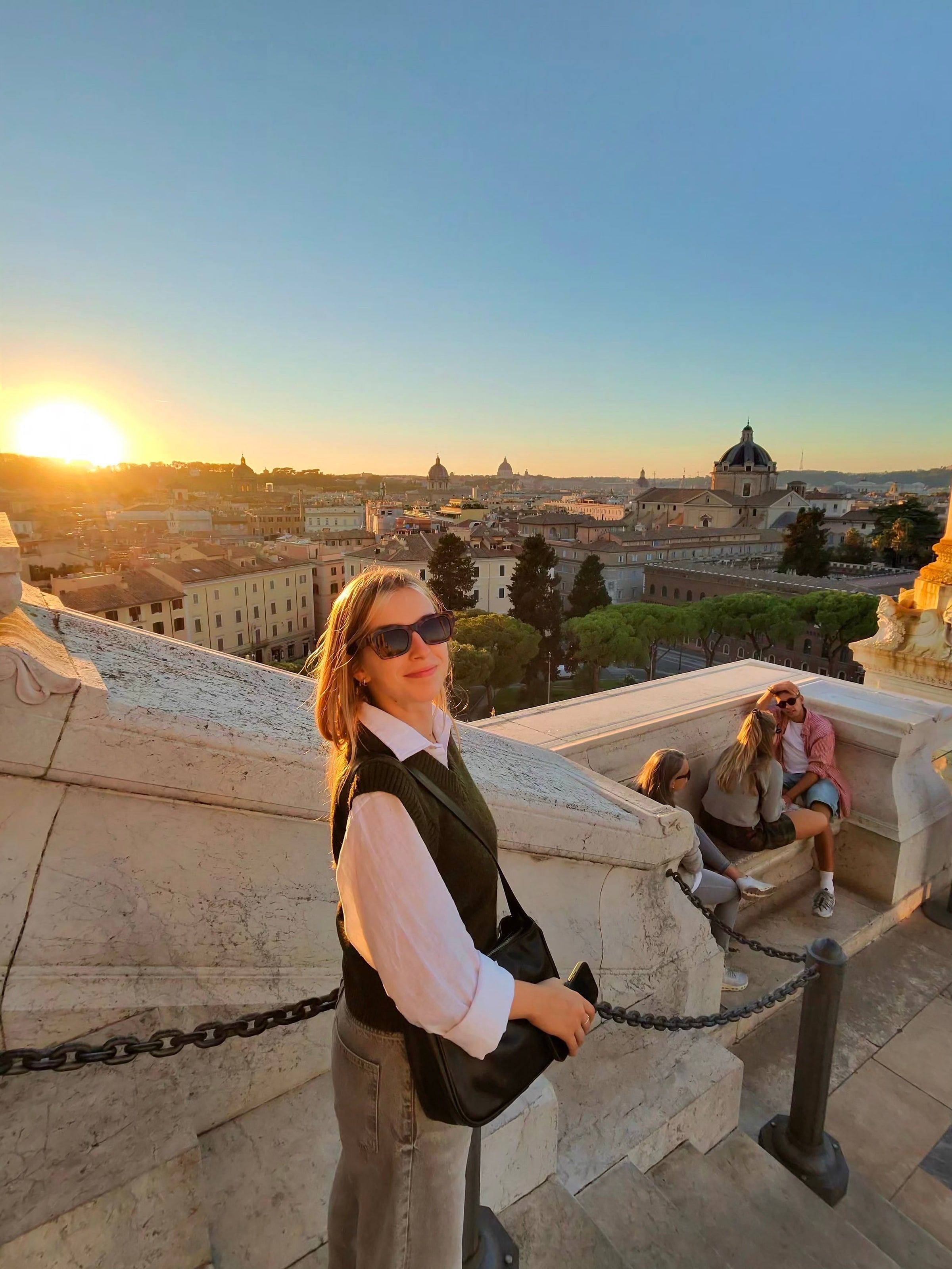 Sentada en el muro del Campidoglio, con Roma al atardecer