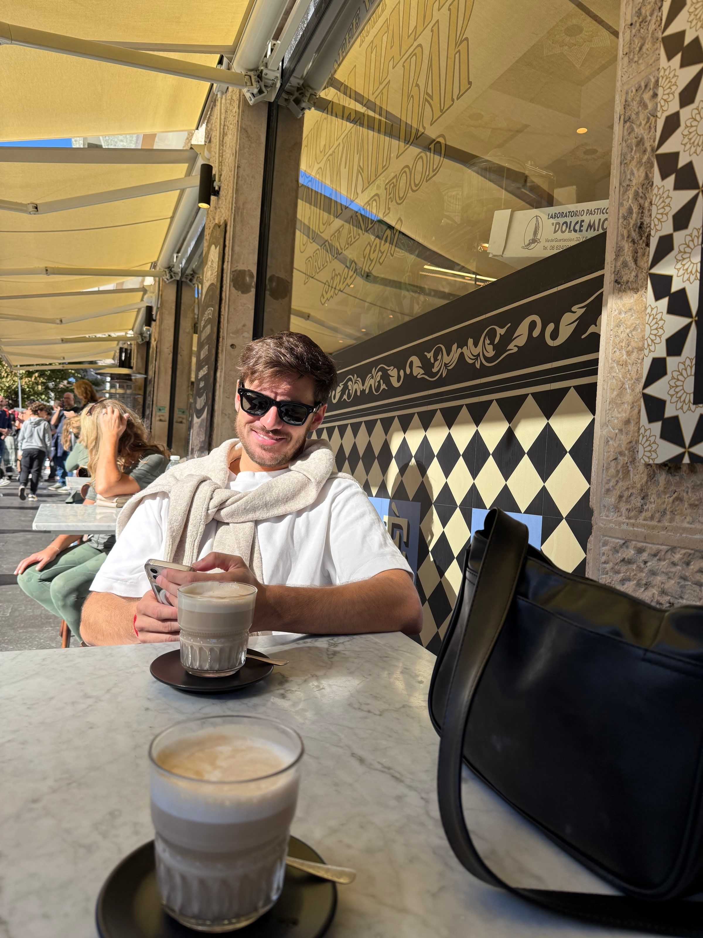 Tomi con un café frente a los muros del Vaticano