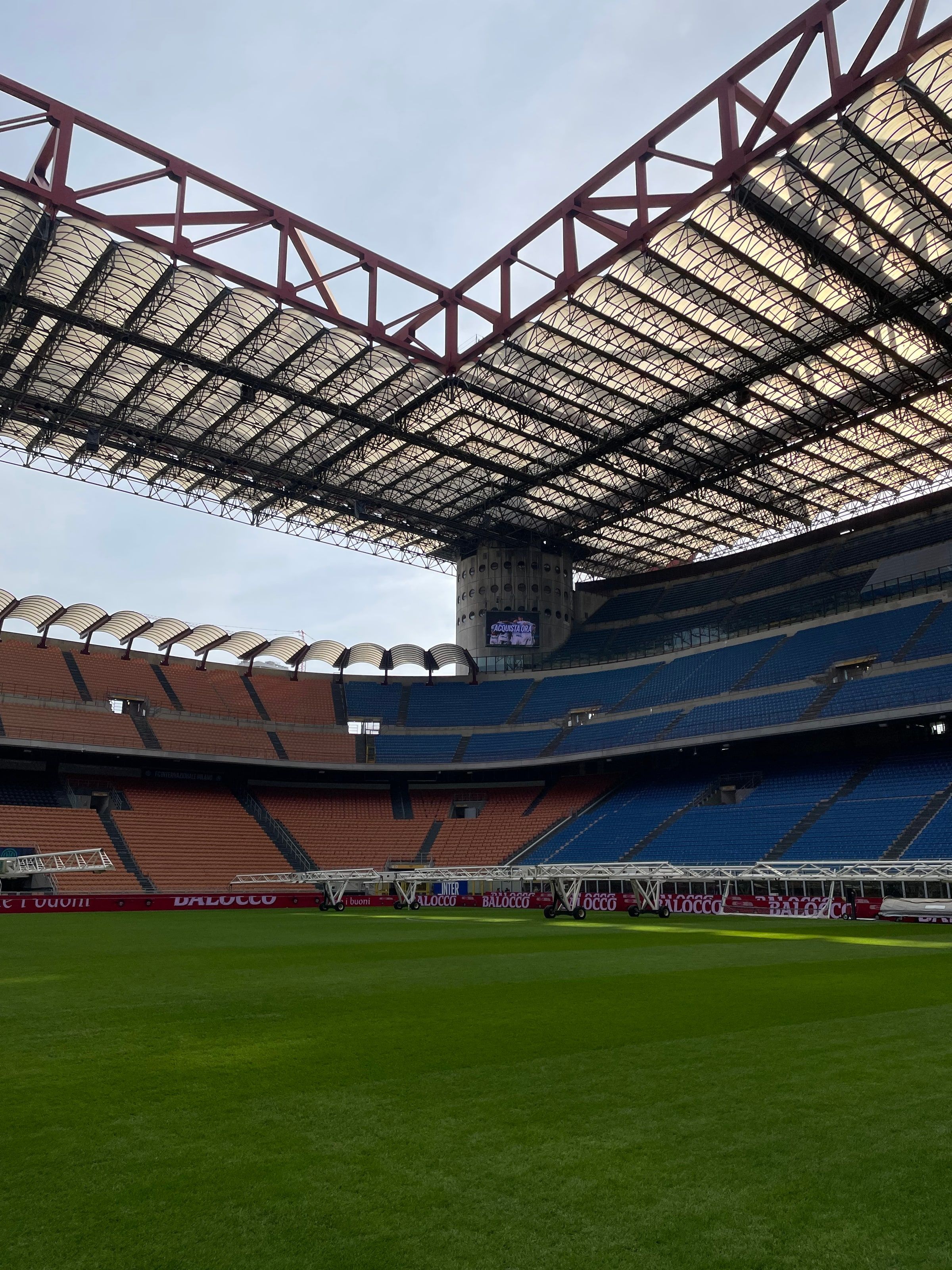 El estadio San Siro vacío, con la tribuna de techo rojo y la cancha