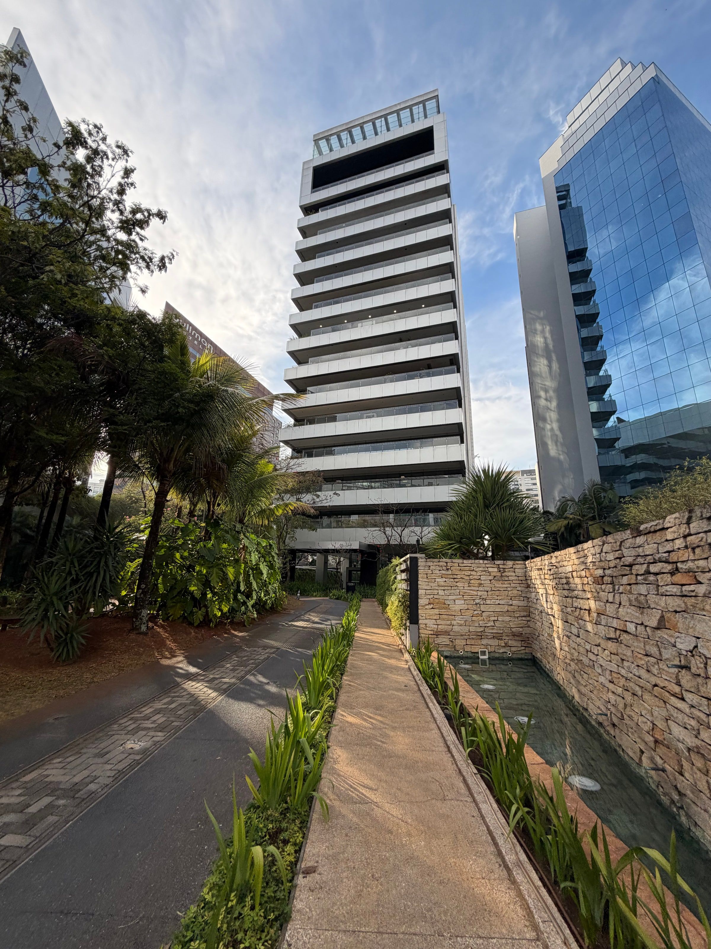 Una calle arbolada de Pinheiros con un edificio escalonado