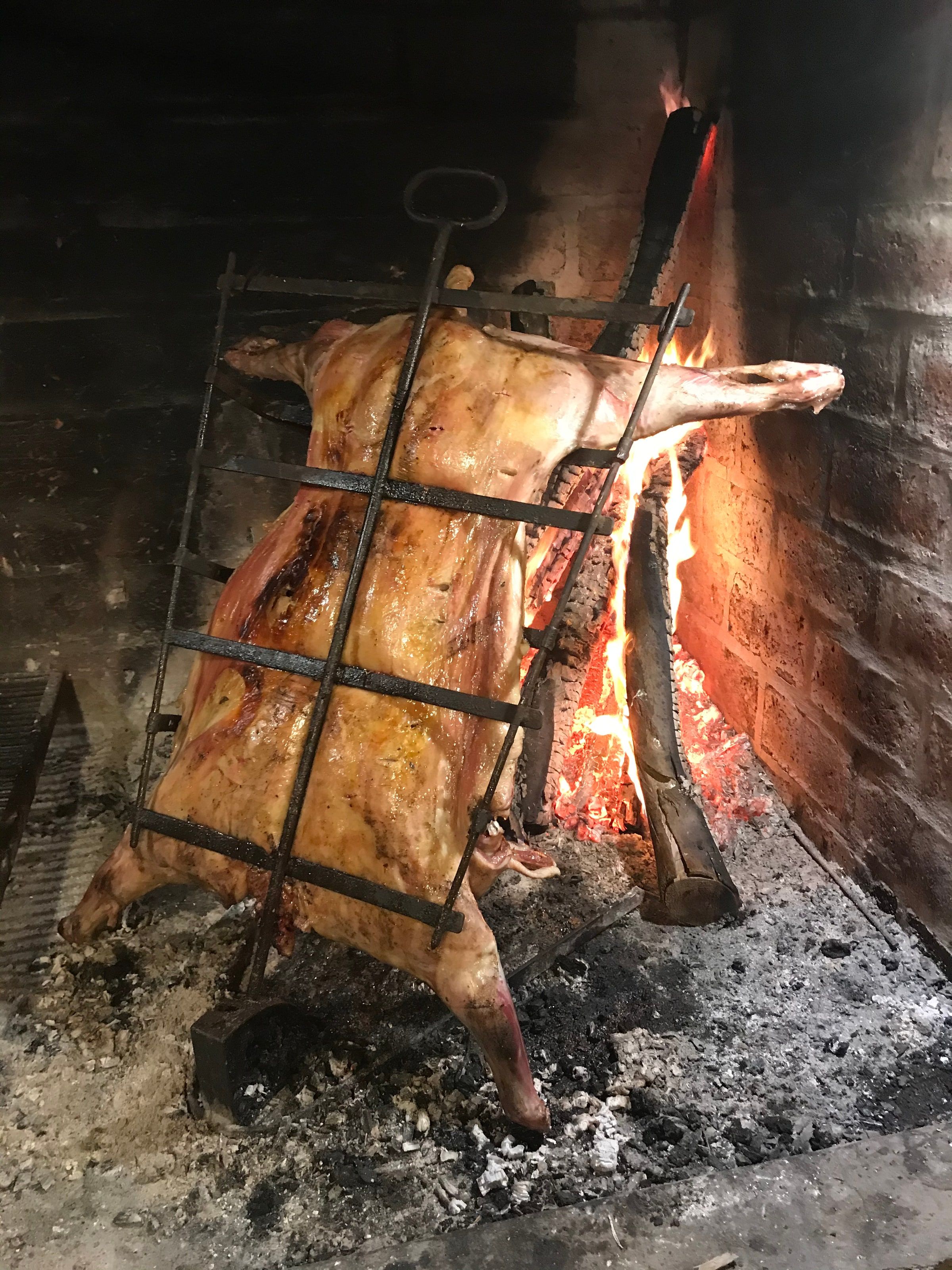 Un asado a la cruz con fuego de leña