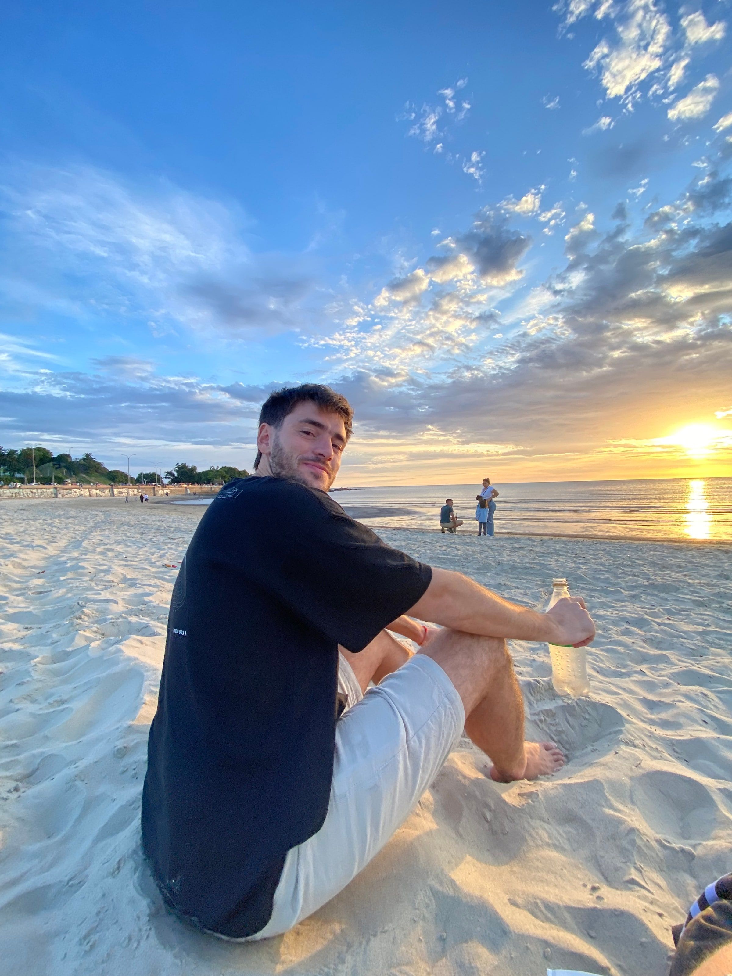 Tomi sentado en la arena de Playa Ramírez al atardecer